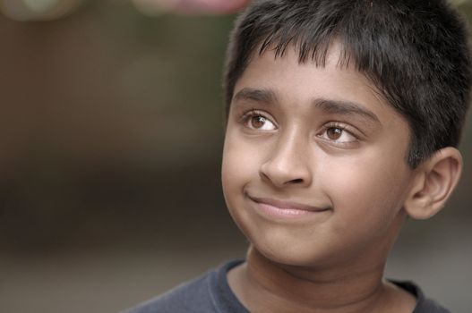 An adorable young Indian boy day dreaming