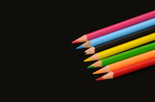 Colored pencils isolated on a black background