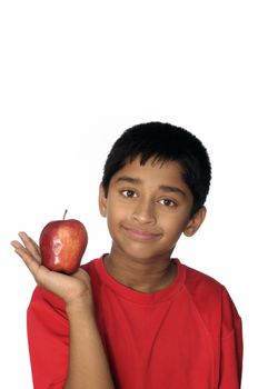 An handsome Indian kid eating apple a day