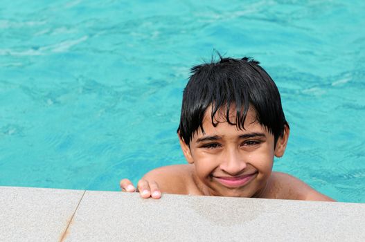 A handsome Indian kid playing in the pool