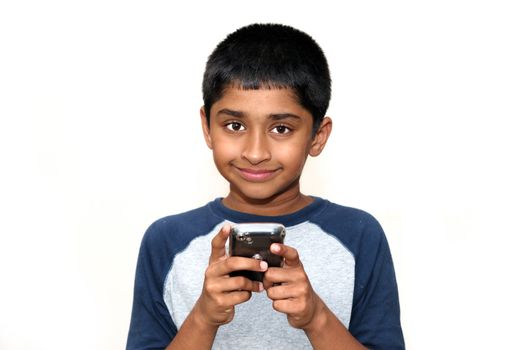 An handsome Indian kid playing games with teh cell phone