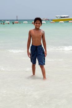 An handsome Indian kid playing in the water