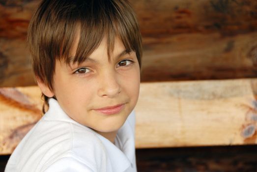 smiling caucasian teenage boy portrait over natural brown background