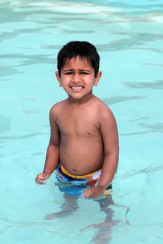 An handsome Indian kid ready to swim by the pool