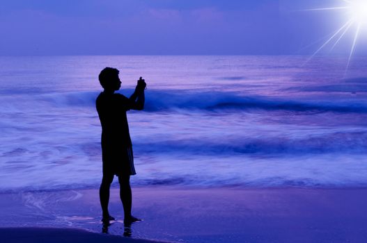 An avid photographer taking picture of the sunrise at the sea