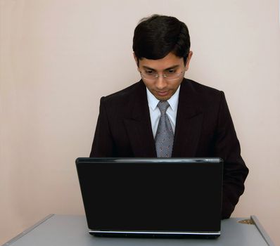 An handsome Indian businessman working on his laptop