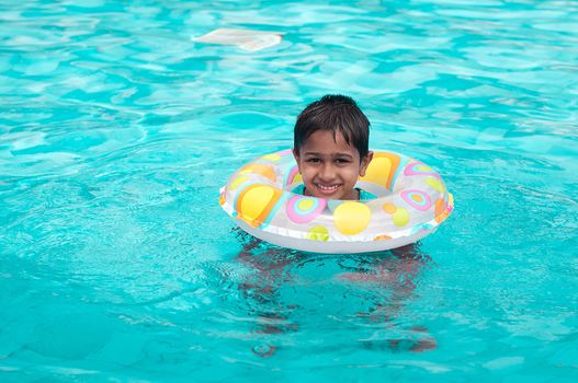 Handsome Indian kid playing in the pool
