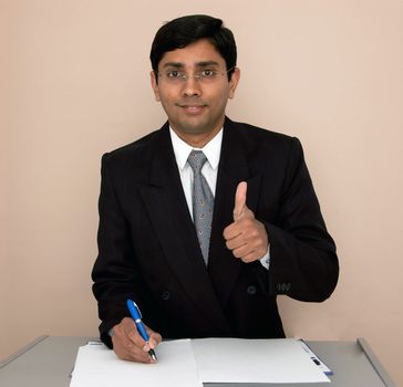 an handsome Indian businessman showing Thumbs up