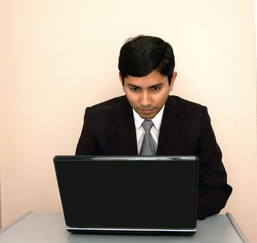 An handsome Indian businessman working with his laptop