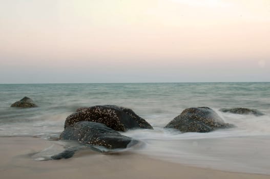 Stormy waves hitting rock on a tropical beach