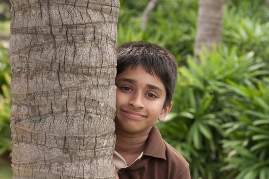 An handsome Indian kid peeping thru the trunk