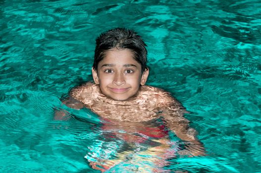 Handsome Indian kid playing in the pool