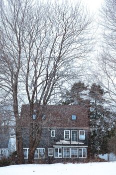 Small Maine house in the winter season during snow storm.