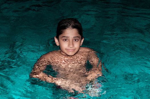 Handsome Indian kid playing in the pool