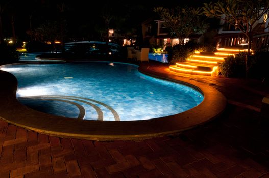 A pretty swimming pool in night at a local resort