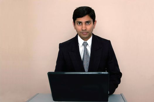 An handsome Indian businessman working on a laptop