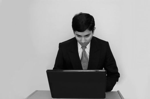 An handsome Indian businessman working on a laptop
