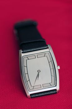 A wrist watch isolated on a red background