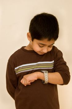 An handsome indian kid keeping track of time