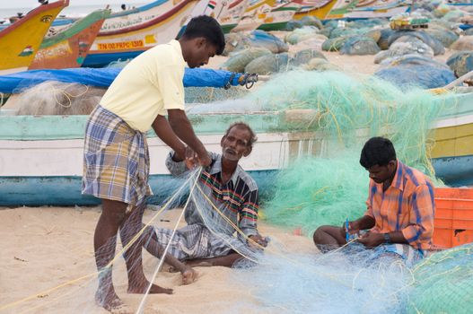 Fisherman weaving nets in the Indian coastline