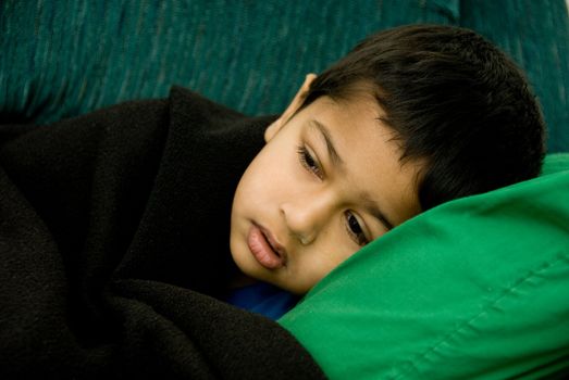 An handsome Indian kid looking very sick