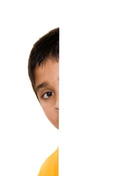 Shy child peeping out of a white door