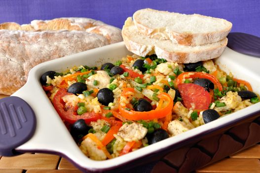 Baked rice with chicken, vegetables and olives in a saucepan
