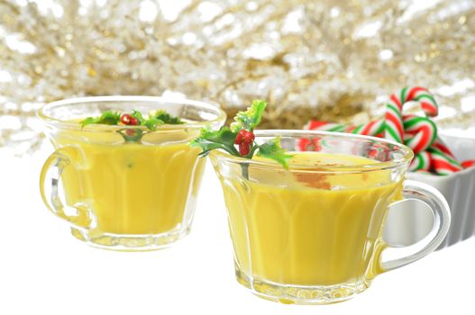Glasses of delicious eggnog garnished with holly.