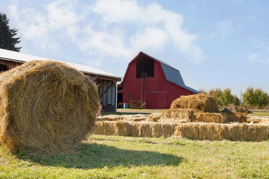 Roll of Hay by the Red Barn with Blue Sky