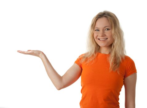 Smiling young woman in orange t-shirt holding her hand palm up, ready to hold your product.