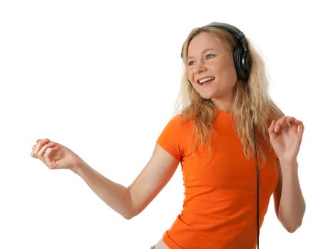 Happy girl in orange t-shirt, listening to music in headphones and dancing.