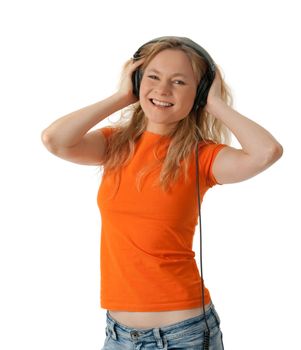 Smiling happy girl in orange t-shirt, listening to music in headphones.