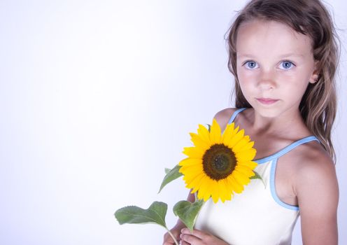 A little girl holding in her hand a beautiful flower