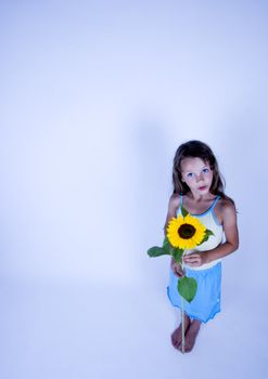 A little girl holding in her hand a beautiful flower