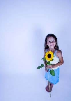 A little girl holding in her hand a beautiful flower