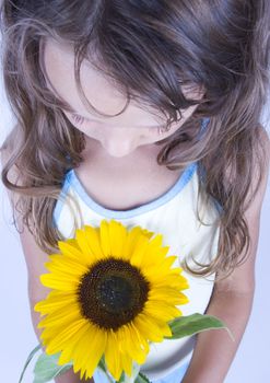 A little girl holding in her hand a beautiful flower