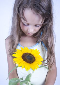 A little girl holding in her hand a beautiful flower