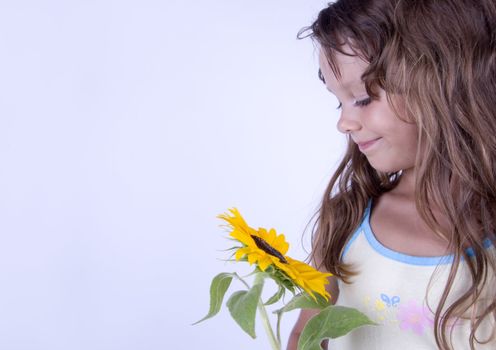 A little girl holding in her hand a beautiful flower