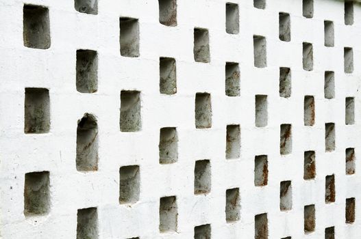 A concrete wall with grid holes.