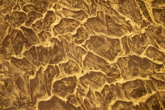 Sand pattern created by water ripple on a sandy beach.