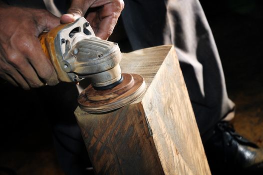 Closeup of a carpenter using a power wood sander.