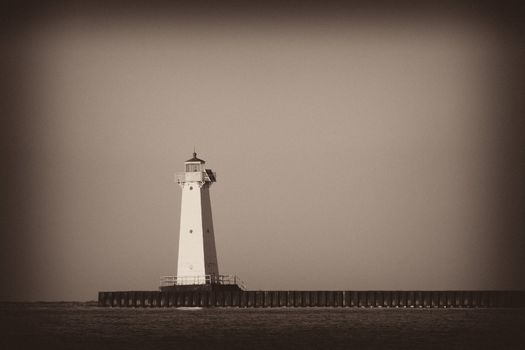 Sodus Bay Lighthouse on Lake Ontario. This is a sepia toned antique style photo.
