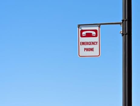 Emergency phone sign with a blue sky background