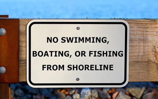 No swimming, boating, or fishing from shoreline sign at a reservoir