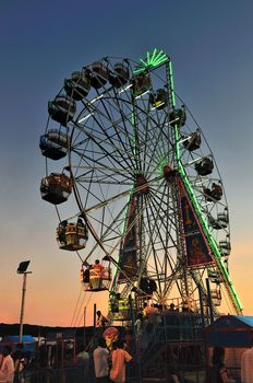 A big giant ferris wheel during a tropical sunset