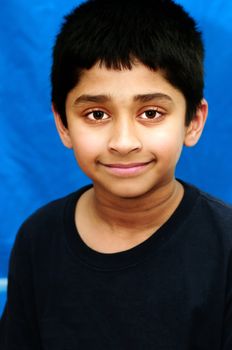 An handsome Indian kid smiling and looking happy