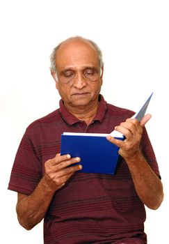 Old Indian Immigrant reading a blue book