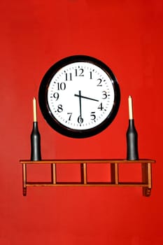 A beautiful walkl clock hanging against a red wall