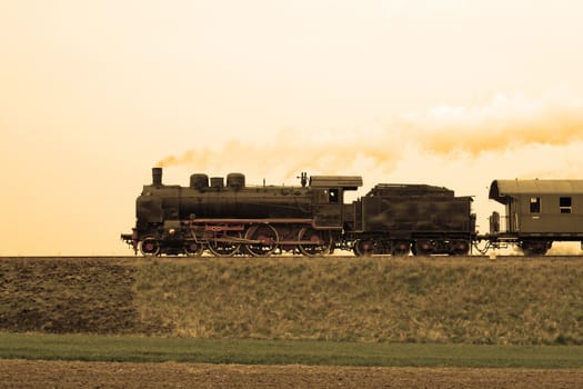 Vintage steam train passing through countryside
