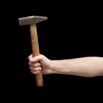 Hammer in a hand isolated on black